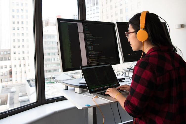 Female web developer wearing orange headphones